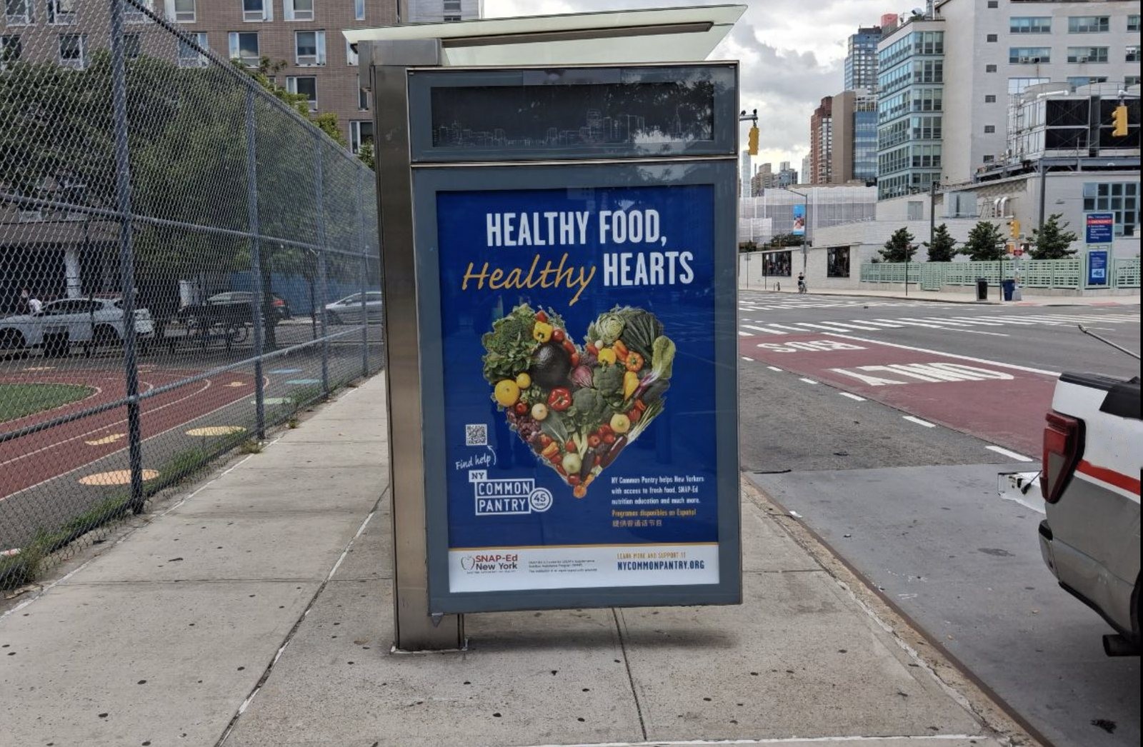 NY Common Pantry bus shelter ad reading Healthy Food, Healthy Hearts beside a bus lane
