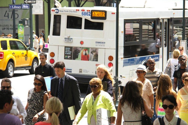 Queens Zoo bus tail on a New York City bus as pedestrians cross the street